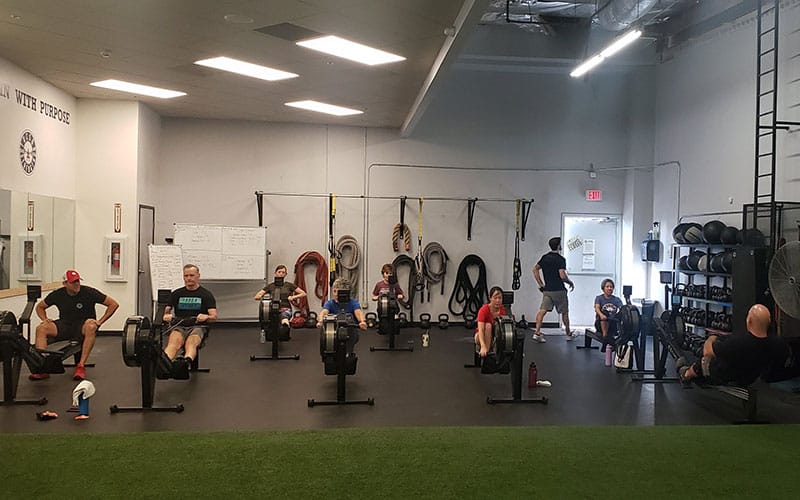 Tucson Strength conditioning classes, featuring a dynamic group of people using rowing machines for conditioning classes.