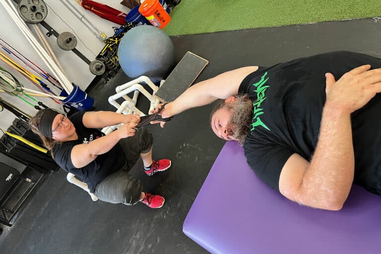 Tucson Strength Certified FST Therapist. Image of Jessica VanAsselberg using Fascial Stretching techniques while working with a client on a Fascial Stretch Therapy session.
