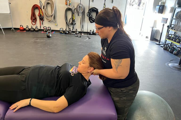 Fascial Stretch Therapist at Tucson Strength Gym. Client on a Fascial Stretch Therapy Session with Certified Fascial Stretch Therapist Jessica VanAsselberg to improve flexibility.