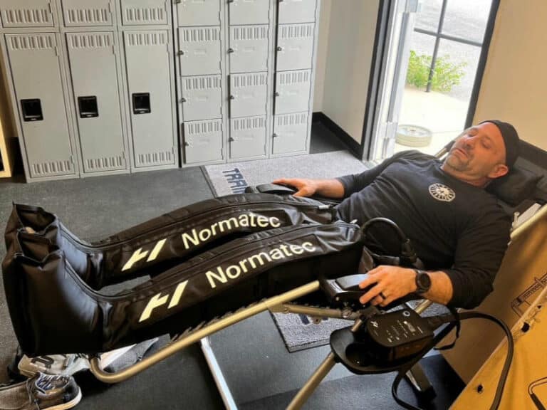 Tucson Strength Sports Recovery Room Normatec Compression Therapy. Client using NormaTec Compression Boots for muscle recovery and relaxation.