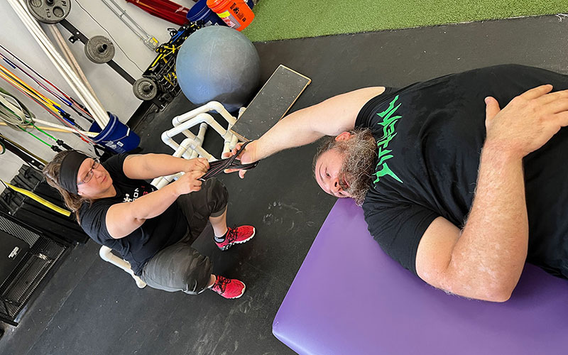 Tucson Strength Services - Fascial Stretch Therapist stretching a client's arm on massage table.