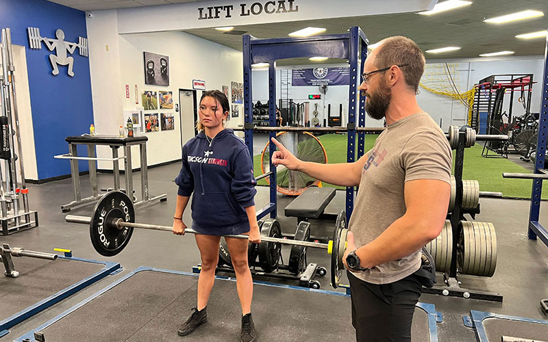 Tucson Strength Services - Personal Training. Personal trainer instructing client on deadlift technique.